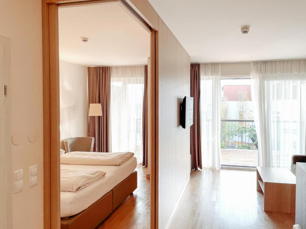 a mirror in a room with a bed and a bedroom at Feel Good Apartments in Krumpendorf am Wörthersee