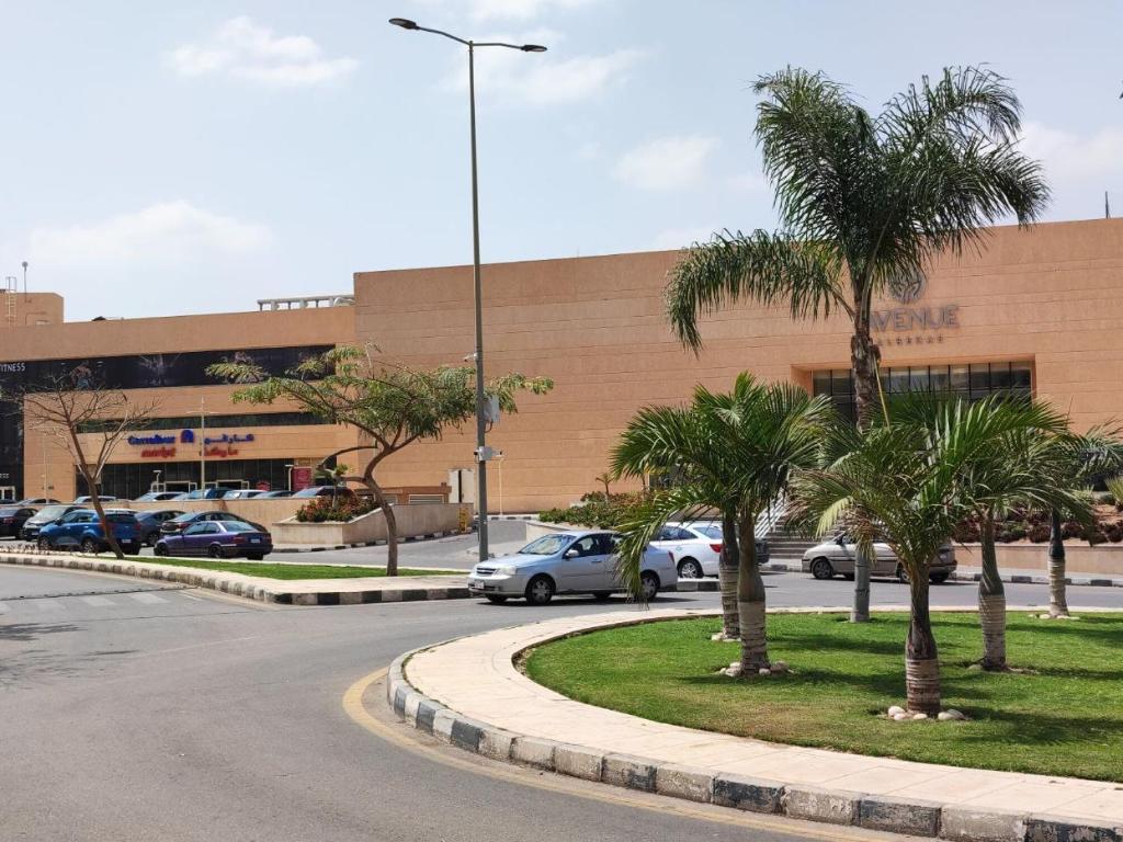 un estacionamiento con autos estacionados frente a un edificio en Al Rehab City, Avenue Mall , New Cairo, en New cairo