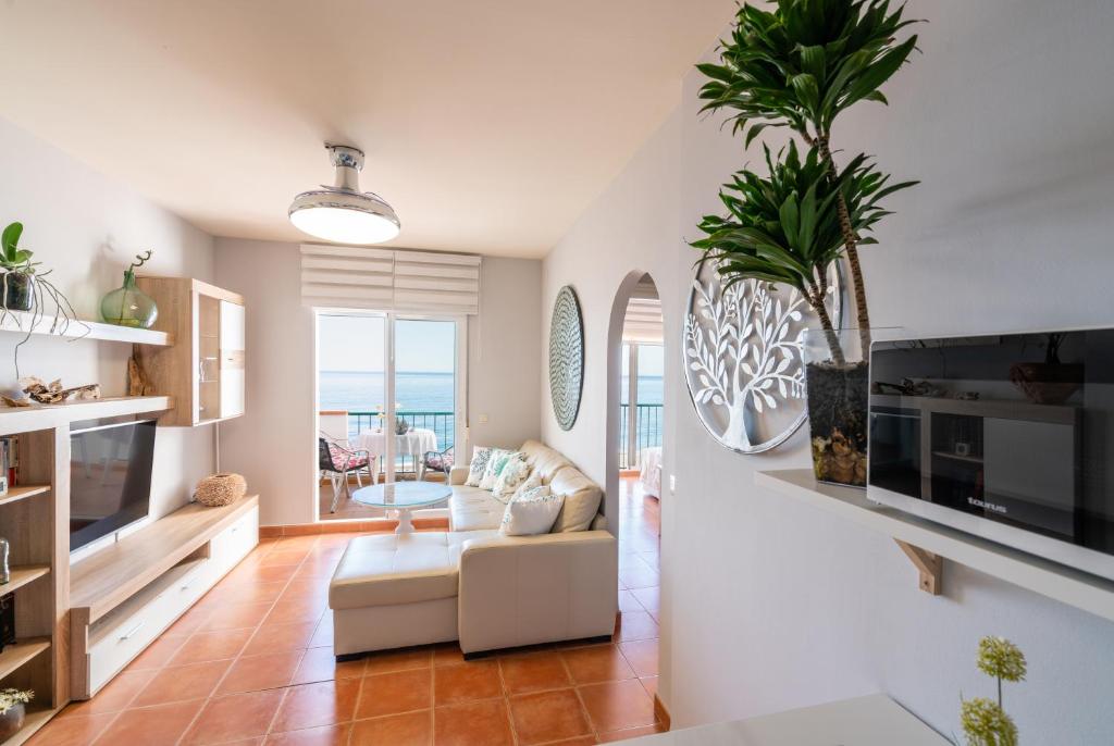 - un salon avec un canapé et une table dans l'établissement Apartamento junto al mar en costa tropical y Alpujarras granadinas, à Melicena