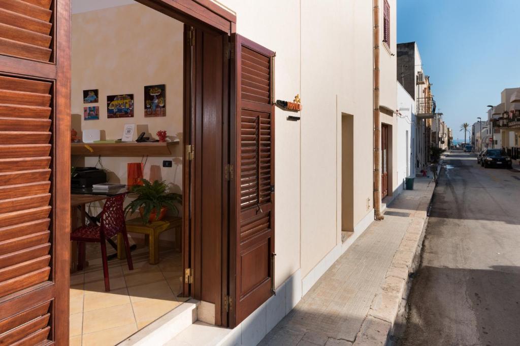an open door on a building with a table on a street at Angolo Arancio Bed & Breakfast in San Vito lo Capo