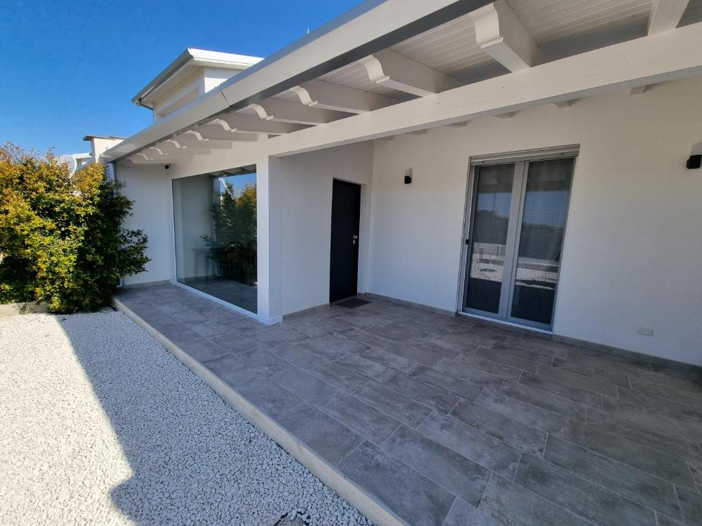 a white house with a large patio at Realmonte Casa vacanze Realbeach in Realmonte