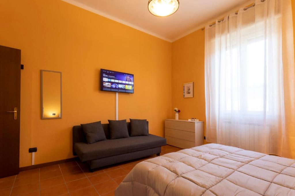 a bedroom with a bed and a couch and a tv at The Novara Gateway - appartamento Novara in Novara