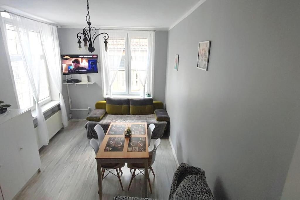 ein Wohnzimmer mit einem Sofa und einem Tisch in der Unterkunft Mieszkanie przy zielonej bramie in Danzig