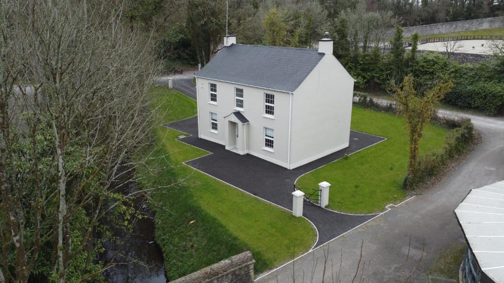 Irvinestown的住宿－The Garden House, Necarne, Irvinestown，草坪上白色房子的空中景色
