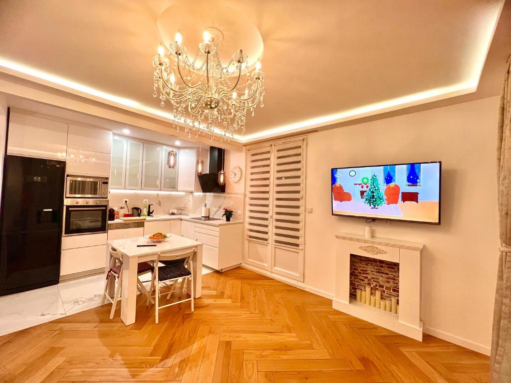 a kitchen with a fireplace and a tv on the wall at Alexandru Home in Boissy-Saint-Léger