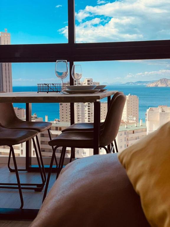 Pokój ze stołem i krzesłami oraz widokiem na ocean w obiekcie GEMELOS 15 TURIS - PREMIUM Apartamentos w mieście Benidorm