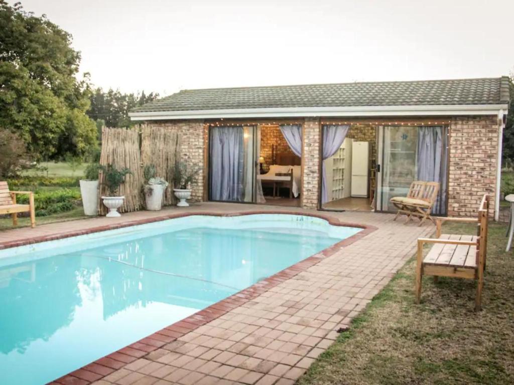 a swimming pool in front of a house at Place of Sonlight in Swellendam