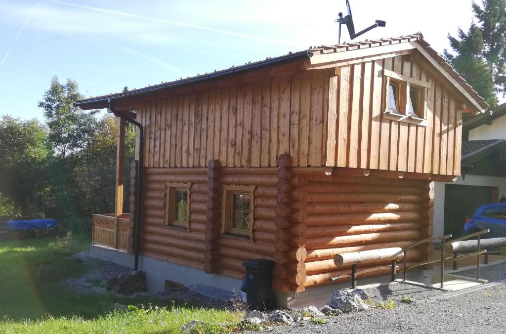 uma pequena cabana de madeira com telhado em Schlossalm Ferienwohnungen em Brannenburg