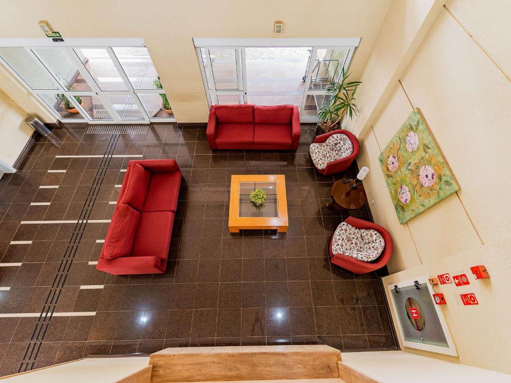 uma vista superior de uma sala de estar com cadeiras vermelhas e uma mesa em Ibis Styles Campinas Alphaville em Campinas