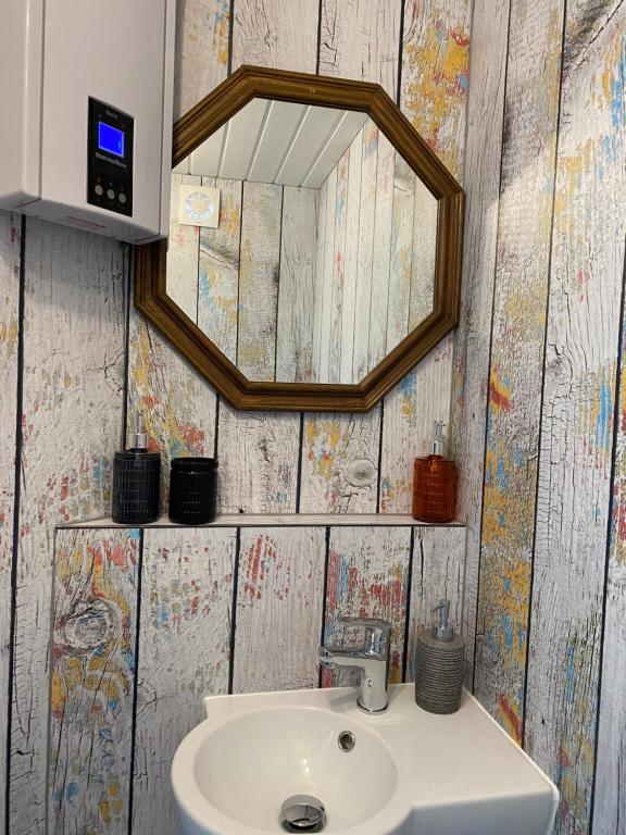 een badkamer met een wastafel en een spiegel bij Gleis 2, Waggon mit Ofen, Whirlpool und Sauna in Dahlem