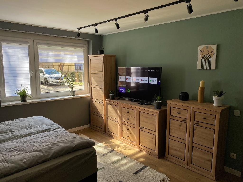 a bedroom with a bed and a flat screen tv at Újhely vára Apartman in Sátoraljaújhely