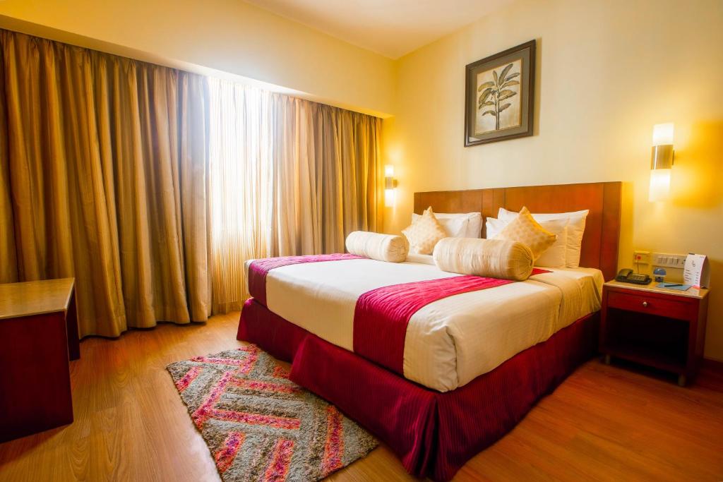 Una habitación de hotel con una cama en una habitación en Evoma, en Bangalore