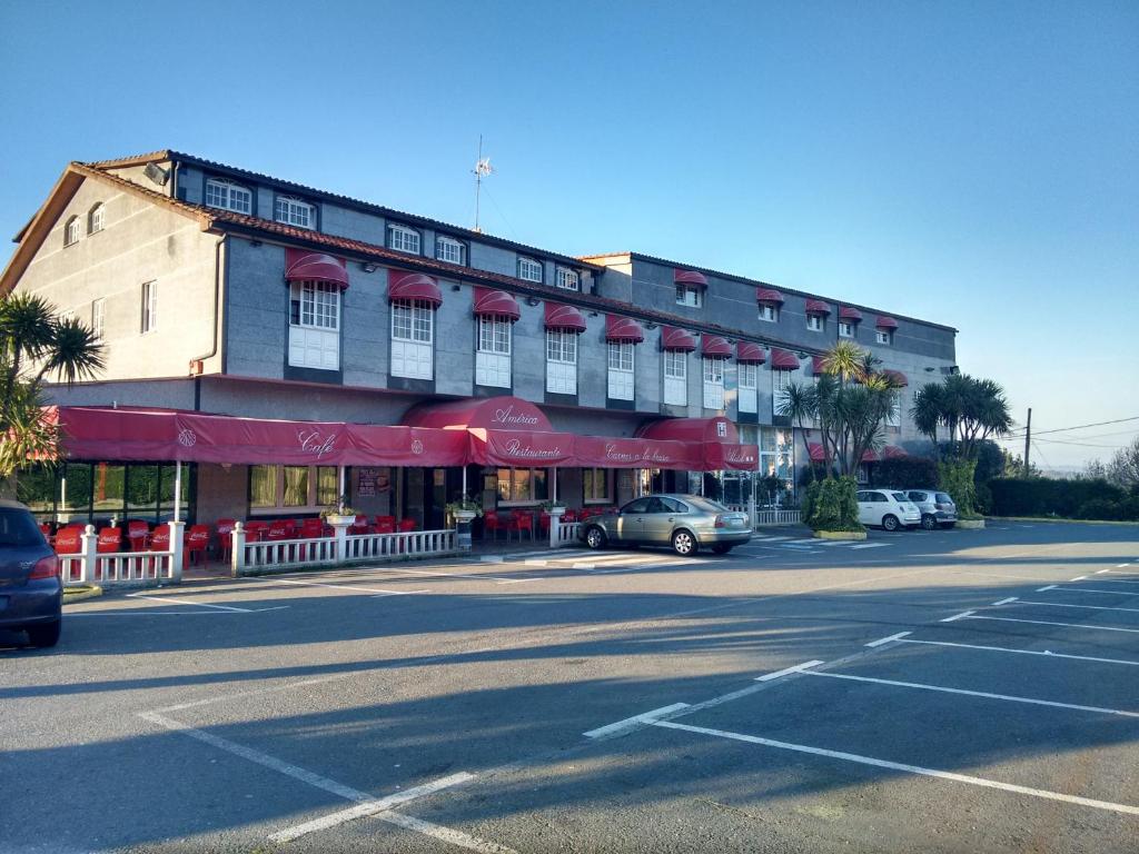 un edificio con coches aparcados frente a una calle en Hotel Restaurante America, en Oca