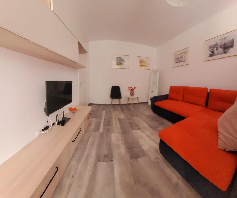 un soggiorno con divano rosso e TV a schermo piatto di 86 Nicolea Labis Coresi a Braşov