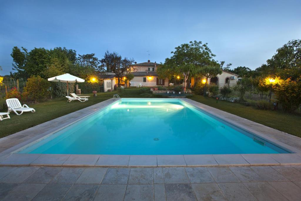 a swimming pool in a backyard at night at Agriturismo Il Fienile in Montepulciano