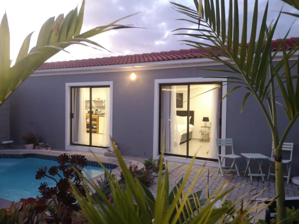 a villa with a swimming pool and a house at Mi Amor self catering apartment in Cape Town