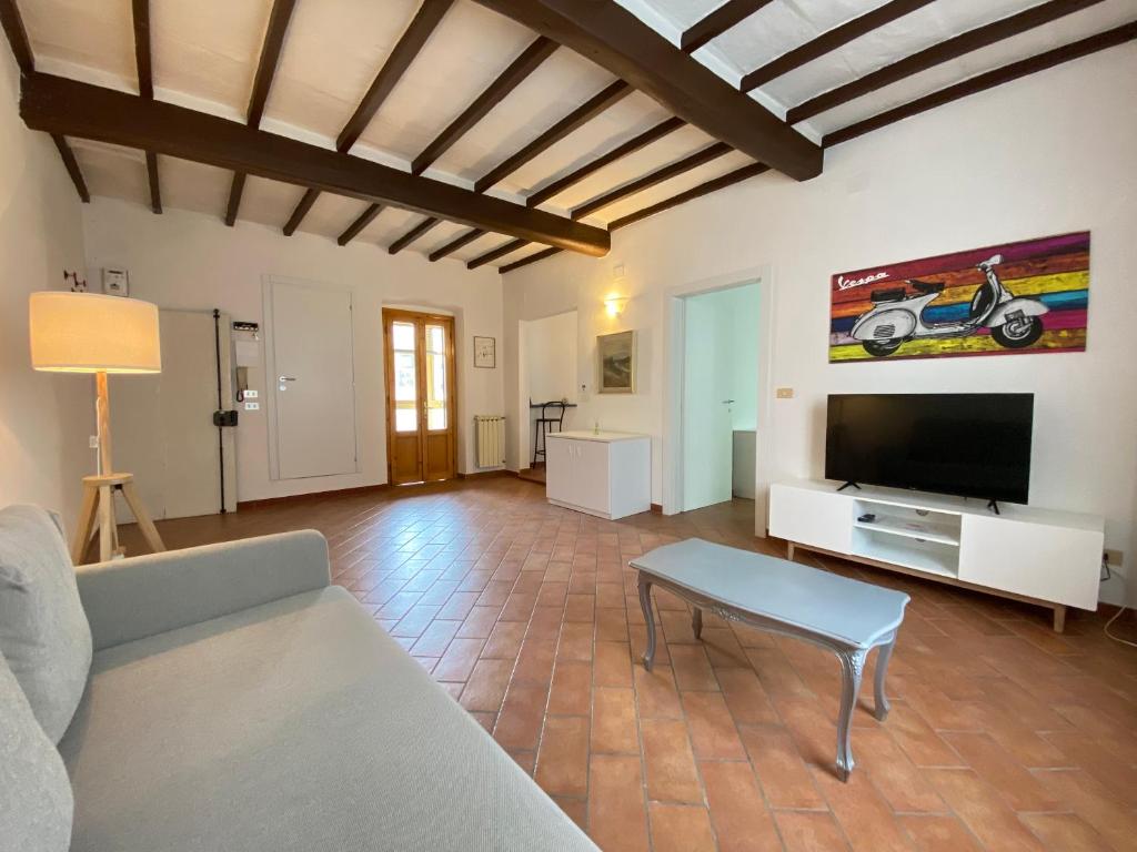a living room with a couch and a flat screen tv at BnBetter - Apartment Teddy, near the Train Station to Florence in Prato