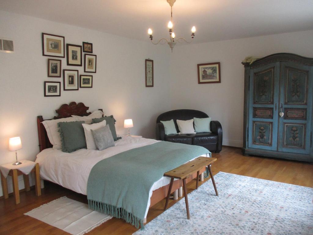 een slaapkamer met een groot bed en een stoel bij La maison de Lili in Guebwiller