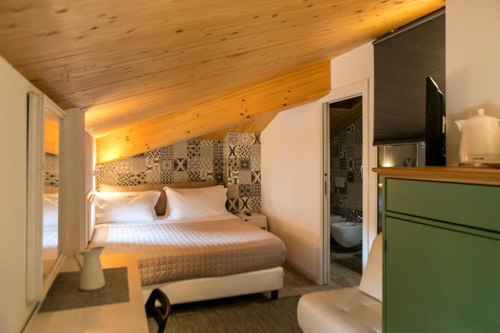 サン・ジョヴァンニ・イン・ペルシチェートにあるAntica Osteria del Mirasoleの木製の天井のベッドルーム1室(ベッド1台付)