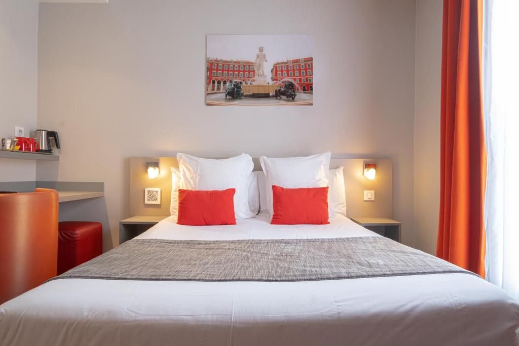 ニースにあるオテル ド ラ フォンテーヌのベッドルーム1室(赤い枕2つ付きのベッド1台付)