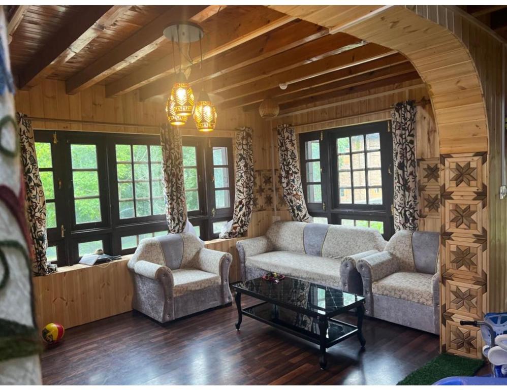 a living room with two couches and a table at Travellers Homestay, Pahalgam in Pahalgām