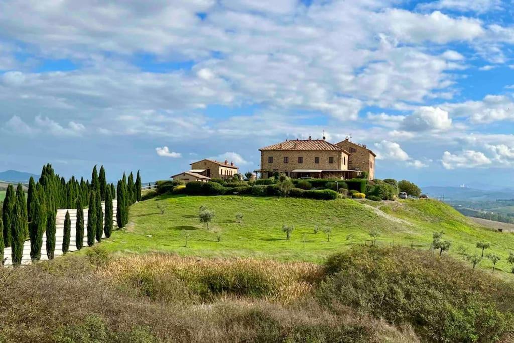 uma casa no topo de uma colina verde com árvores em Toscana Amore Mio, stunning view & 14min Volterra em Montecatini Val di Cecina