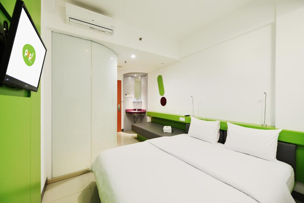 Postel nebo postele na pokoji v ubytování POP! Hotel Malioboro - Yogyakarta