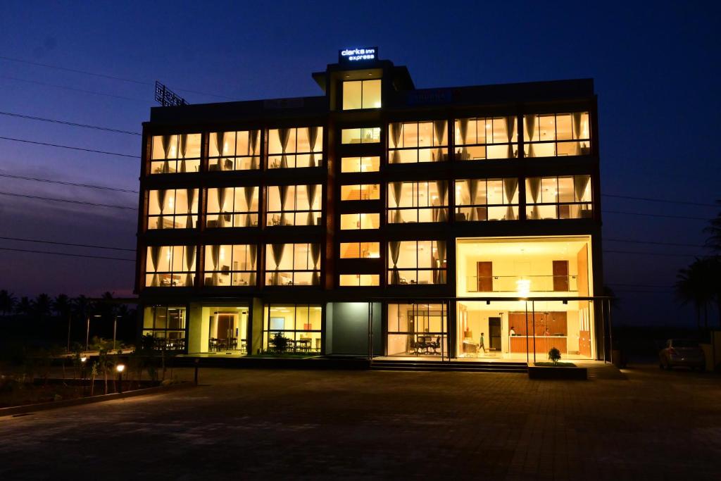 マイソールにあるClarks Inn Express, KRS road-Mandya, Mysoreの夜間の照明付き窓のある大きな建物