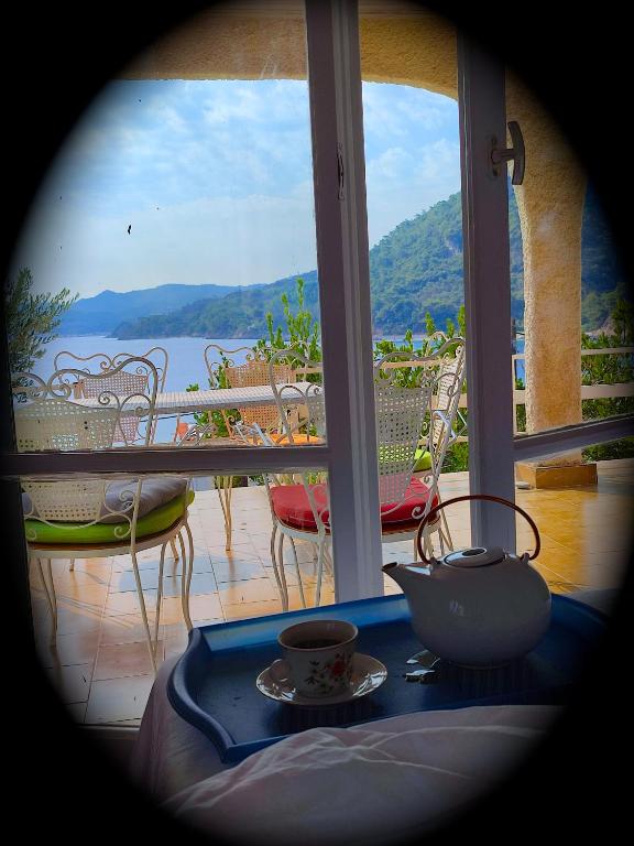 a view of a balcony with a table with a cup of coffee at Lilly's Seaview Retreat Cottage in Avlákia