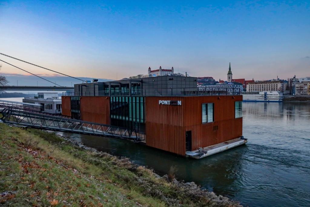 um barco casa na água em um rio em Ponton Rooms em Bratislava
