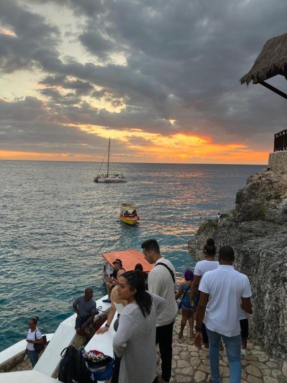 a group of people standing on the side of a boat in the ocean at Su Casa Bonita, Negril in Negril