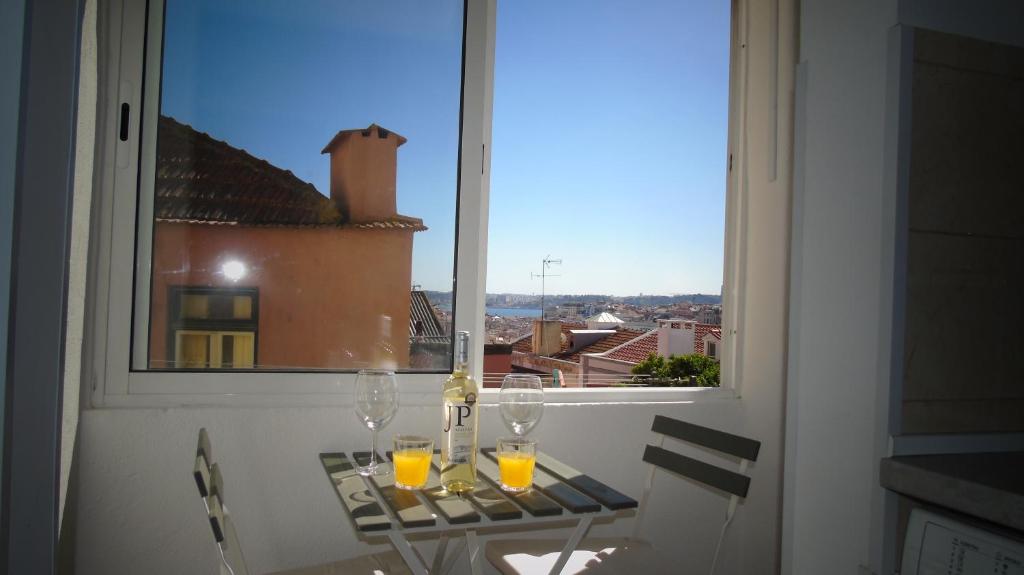 einen Tisch mit Brille und Fenster in der Unterkunft Graça River View in Lissabon