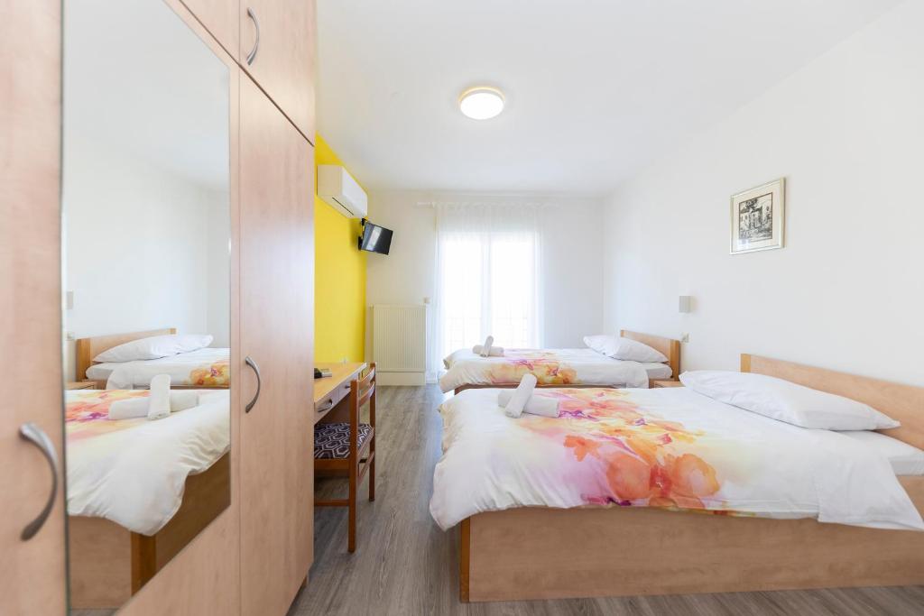 1 dormitorio con 2 camas y escritorio. en Guesthouse Villa Irena, en Zadar