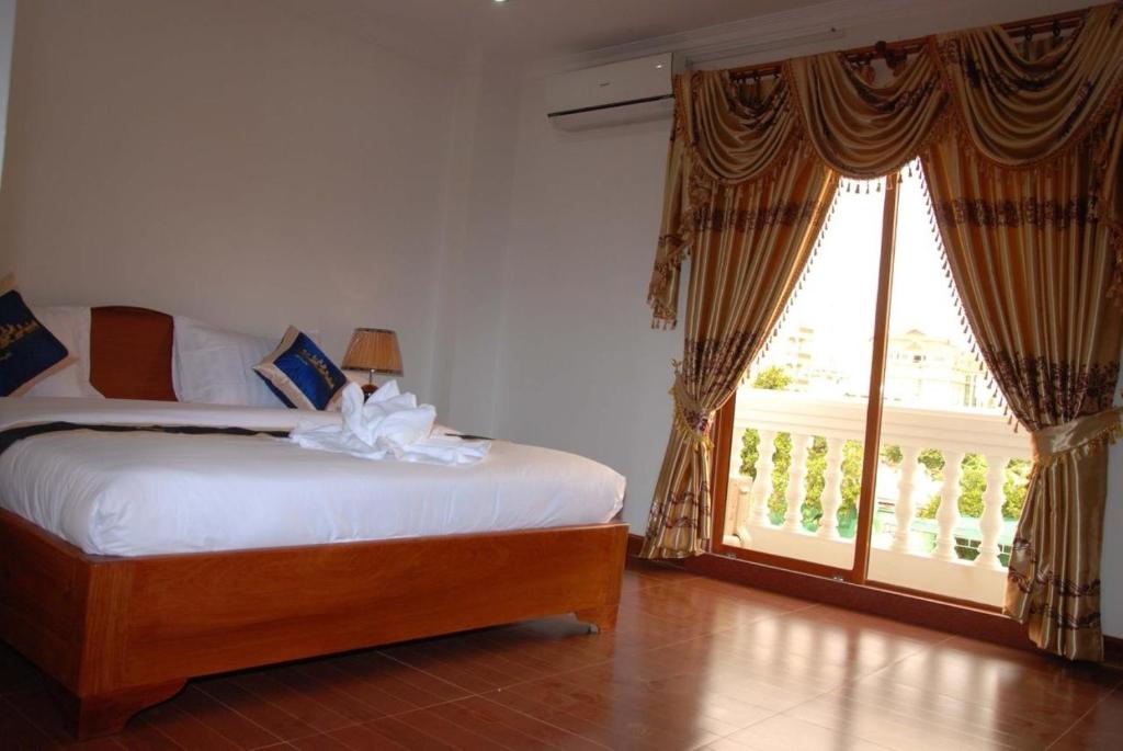 Postel nebo postele na pokoji v ubytování Emerald BB Battambang Hotel