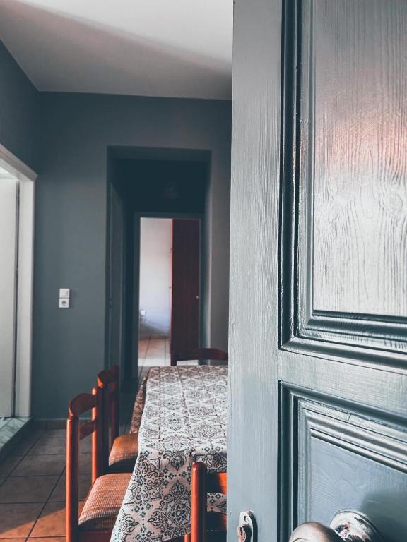 a room with a table and chairs and a door at CENTRAL APARTMENTs in Ermoupoli