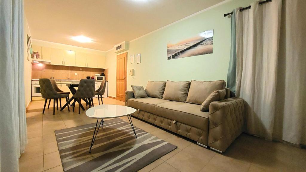 een woonkamer met een bank en een tafel bij Sea View Garden Apartment in Budva