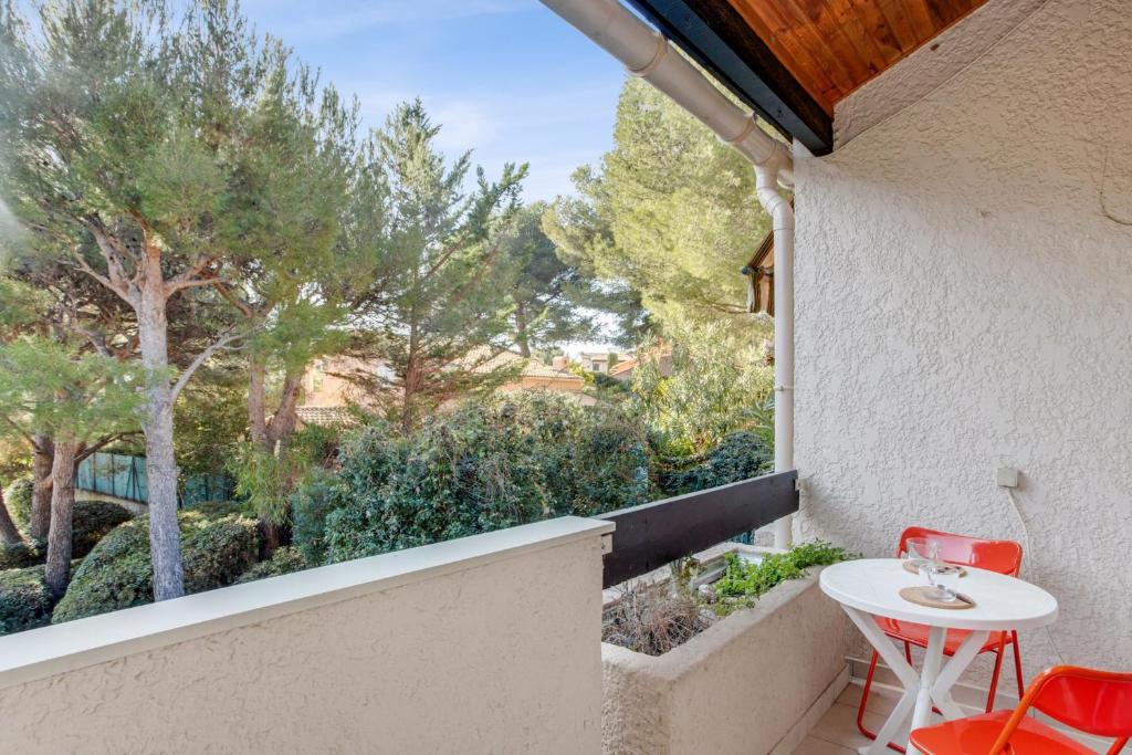 - un balcon avec une table, des chaises et des arbres dans l'établissement Duplex Cigarra - Welkeys, à Bandol
