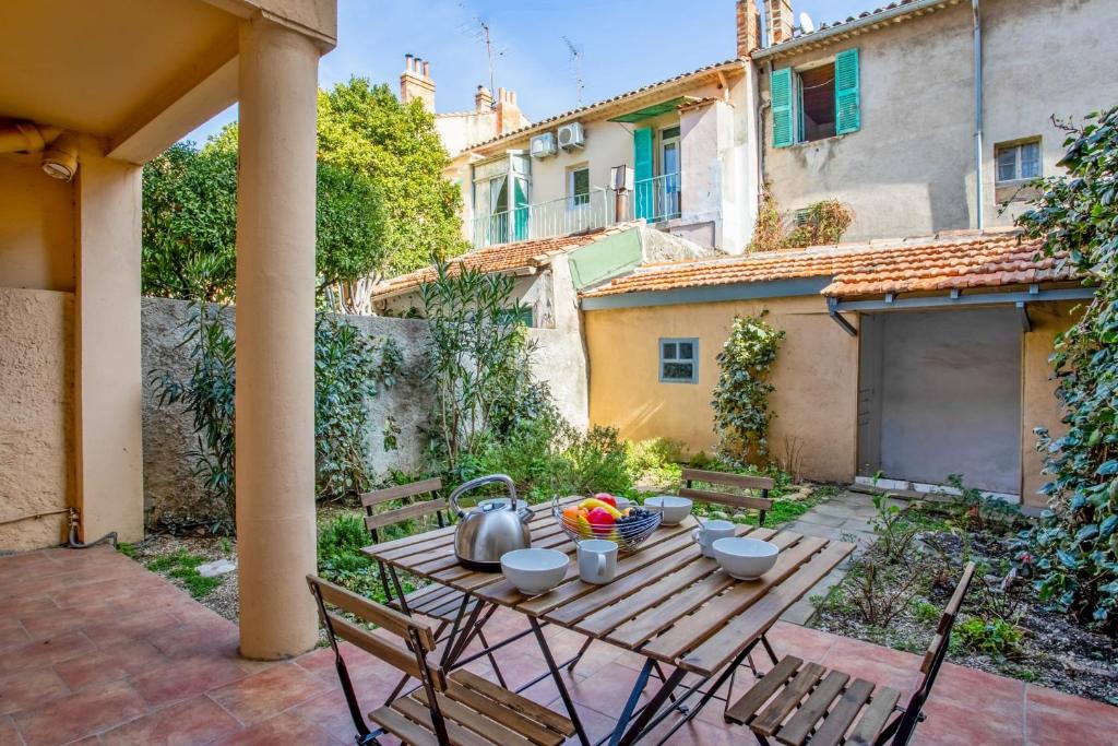 einen Holztisch mit einer Schüssel Essen auf einer Terrasse in der Unterkunft Maison Castel - Welkeys in Toulon