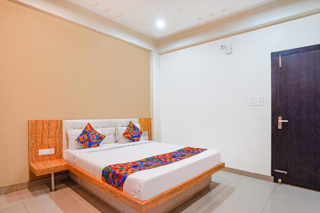 ein Schlafzimmer mit einem Bett in einem Zimmer in der Unterkunft FabHotel Bliss Inn in Prayagraj
