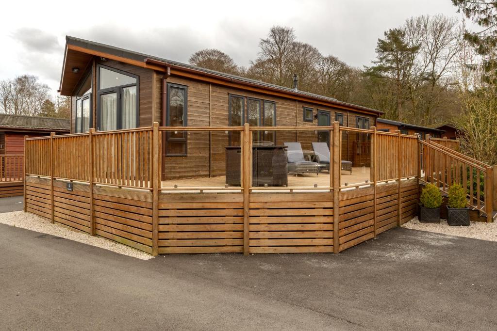a large wooden house with a large deck at Lakeside 4 Lodge in Windermere