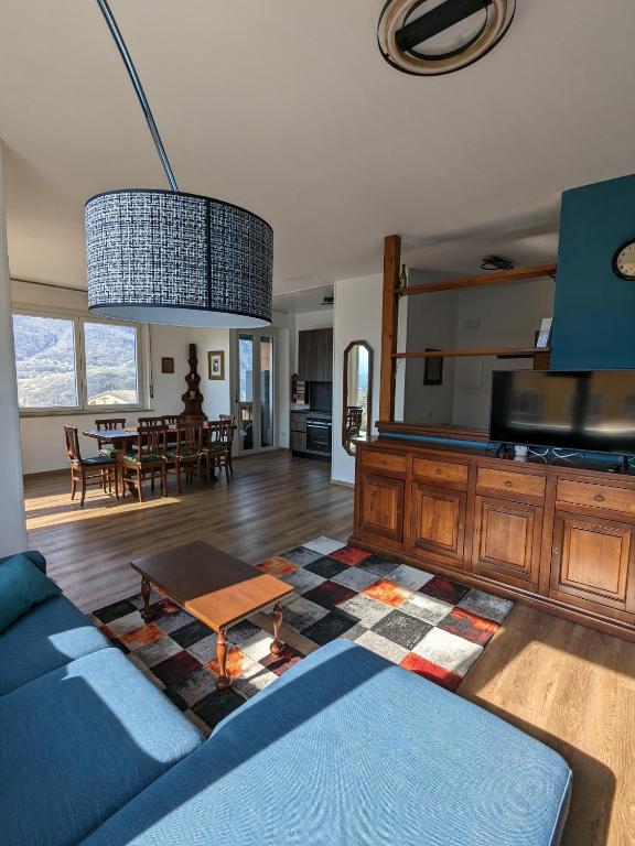a living room with a blue couch and a table at Maison Alice in Saint Vincent