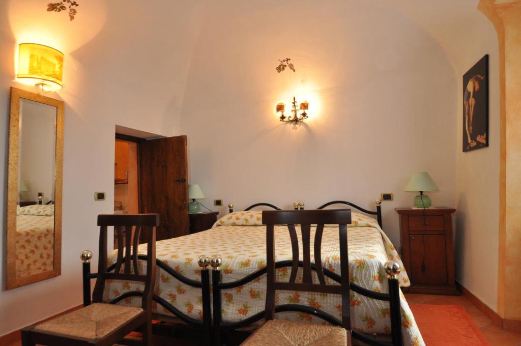 a bedroom with a bed with two chairs at B&B Casa Camilla - Affitti Brevi Italia in Niella Tanaro