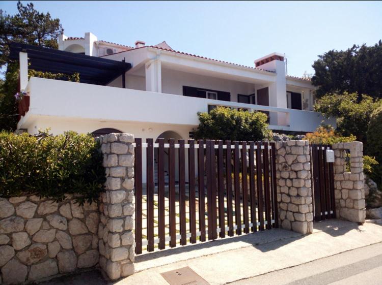 a fence in front of a white house at APARTMENT KORI in Baška