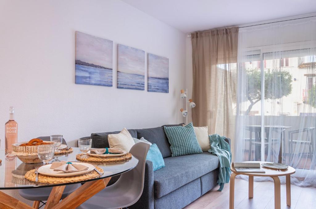 een woonkamer met een bank en een tafel bij Apartamento con terraza y vistas al canal by InsideHome in Empuriabrava