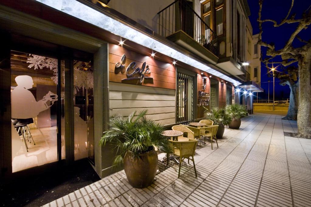 a patio with tables and chairs outside of a building at Hotel Jardí Apartaments in Mollerussa