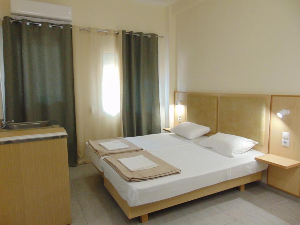 una camera da letto con un grande letto bianco e una finestra di Sweetmar-Ground floor-Guest rooms a Città di Kos