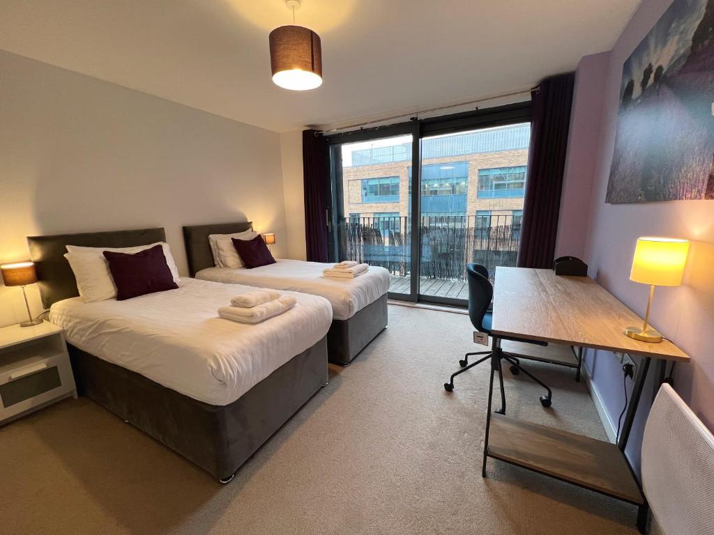 a bedroom with two beds and a desk and a window at Glorious 2BR APT in Maidenhead Town Centre - FREE Parking, Wi-Fi & Netflix - By JDF Property in Maidenhead