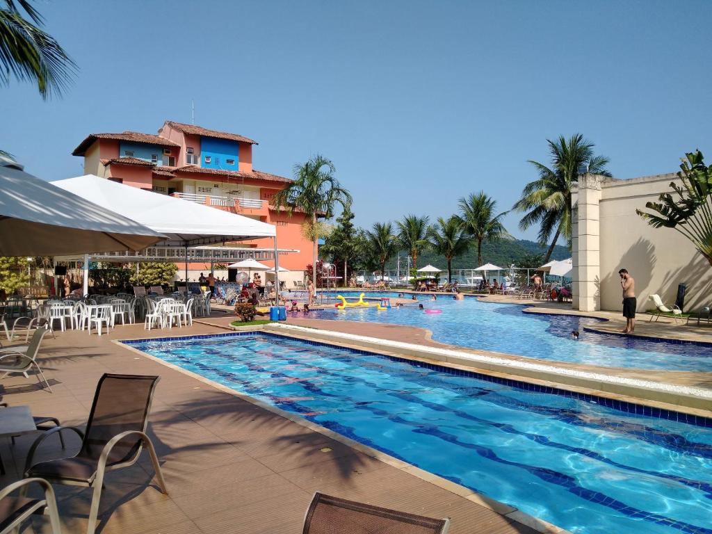 uma piscina num resort com uma pessoa ao lado em Porto Marina Mont Blanc Resort II em Mangaratiba