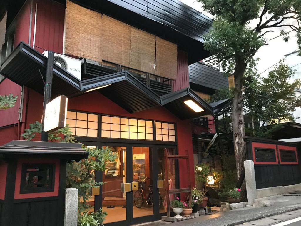 un restaurante con un edificio rojo con balcón en Sakaenoyu Ryokan, en Matsumoto