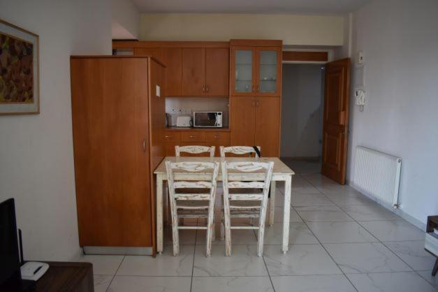 a kitchen with a white table and chairs in a room at Klimentos Flat 58 in Nicosia